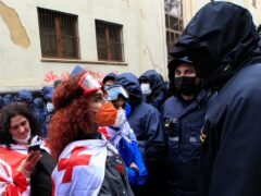 A demonstrator wears a national flag as she argues with the police during an opposition protest against ‘the Russian law’ in Tbilisi, Georgia (Shakh Aivazov/AP)