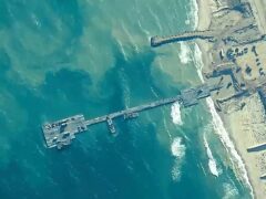 US Army soldiers assigned to the 7th Transportation Brigade (Expeditionary), US Navy sailors assigned to Amphibious Construction Battalion 1, and Israel Defence Forces placing the Trident Pier on the coast of the Gaza Strip on May 16 (US Central Command via AP)