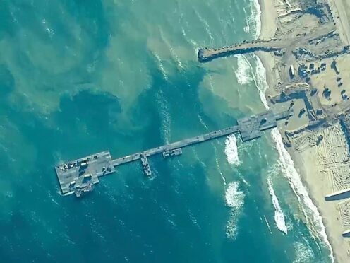 US Army soldiers assigned to the 7th Transportation Brigade (Expeditionary), US Navy sailors assigned to Amphibious Construction Battalion 1, and Israel Defence Forces placing the Trident Pier on the coast of the Gaza Strip on May 16 (US Central Command via AP)