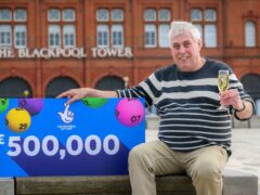 Lottery winner Raymond Young celebrates his win in front of the Blackpool Tower (Anthony Devlin/National Lottery/PA)