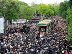 Mourners gather around a truck carrying coffins of Iranian President Ebrahim Raisi and his companions who were killed in a helicopter crash (Ata Dadashi, Fars News Agency via AP)