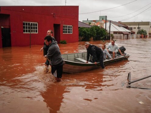 People evacuate a flooded area after heavy rain in Sao Sebastiao do Cai, Brazil (AP Photo/Carlos Macedo)