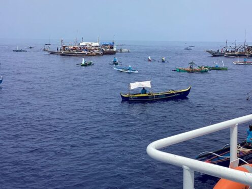 Fishing boats carrying Filipino activists and volunteers head towards a disputed shoal in the South China Sea (Philippine Coast Guard via AP)