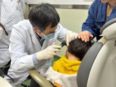 Dr Yilai Shu examines a young patient (Eye & ENT Hospital of Fudan University/PA)