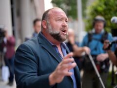 Conspiracy theorist Alex Jones speaks to the media after arriving at court for an earlier hearing (David J Phillip/AP)