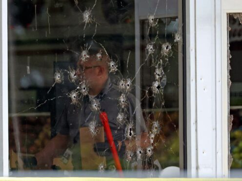 Several bullet holes were left in the windows of the shop following the shooting (Colin Murphey/Arkansas Democrat-Gazette/AP)