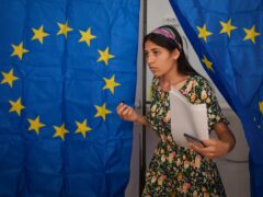 A woman exits a voting booth after casting her vote in European Parliament and local elections in Baleni, Romania (Vadim Ghirda/AP)