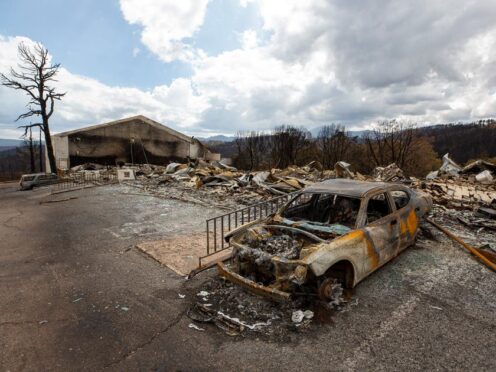 A charred car and the remains of the Swiss Chalet Hotel after being destroyed by the South Fork Fire in the mountain village of Ruidoso (Andres Leighton/AP)