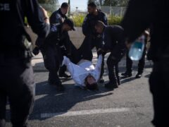 Israeli police officers remove an ultra-Orthodox Jewish man from the street (Leo Correa/AP)