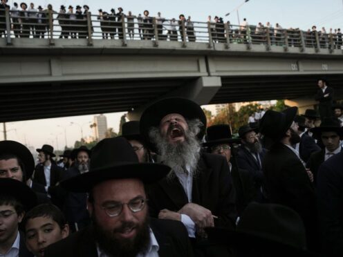 Ultra-Orthodox Jewish men block a main road during a protest against army recruitment in Bnei Brak, Israel, on Thursday (Oded Balilty/AP)