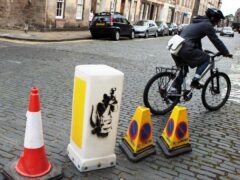 A bollard featuring one of Banksy’s rats is going under the hammer in an auction of street art (David Cheskin/PA)