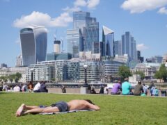 People enjoy the hot weather with a view of the City of London. London stocks climbed higher on Monday (Lucy North/PA)