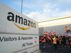 Members of the GMB union on the picket line stand in front of a freight lorry outside the Amazon fulfilment centre in Coventry (Jacob King/PA)