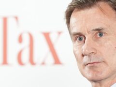 Chancellor Jeremy Hunt in front of a white background with the word ‘Tax’ on it (Aaron Chown/PA)