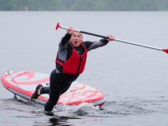 Liberal Democrat leader Sir Ed Davey falls into the water while paddleboarding on Lake Windermere (Peter Byrne/PA)