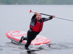 Liberal Democrat Leader Sir Ed Davey falls into the water while paddleboarding on Windermere, while on the General Election campaign trail (Peter Byrne/PA)
