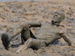 A competitor takes part in the annual Maldon Mud Race, a charity event to race across the bed of the River Blackwater in Maldon, Essex (Gareth Fuller/PA)