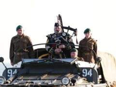 Military piper Major Trevor Macey-Lillie on a DUKW amphibious vehicle ahead of playing a dawn lament on Gold Beach in Arromanches in Normandy (Aaron Chown/PA)