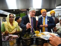 SNP leader John Swinney, with parliamentary candidate Chris Stephens in the kitchens during their visit to the Glasgow Gurdwara (Andy Buchanan/PA)