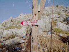 A sign points to Saint Nikolas beach in the Pedi area of Symi, Greece, where a search and rescue operation is under way for TV doctor and columnist Michael Mosley after he went missing while on holiday (Yui Mok/PA)