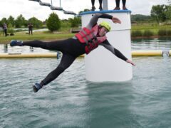 Liberal Democrats leader Sir Ed Davey falls as he attempts an Aqua Jungle floating assault course during a visit to Spot-On-Wake in Henley-in-Arden, Warwickshire (Jacob King/PA)