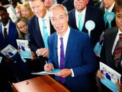 Reform UK leader Nigel Farage signs a copy of his party’s ‘Our Contract with You’ following its launch in Merthyr Tydfil, while on the General Election campaign trail (PA)