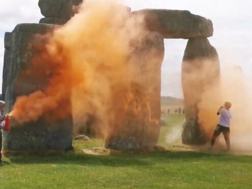 Just Stop Oil protesters spraying an orange substance on Stonehenge (Just Stop Oil/PA)