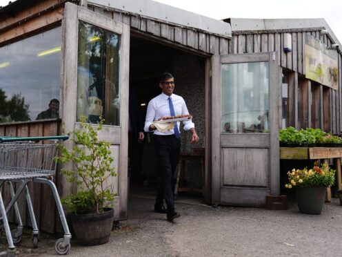 Rishi Sunak handed out Bara Brith cake to the media during a visit to a farm shop in Mold on Friday (Aaron Chown/PA)