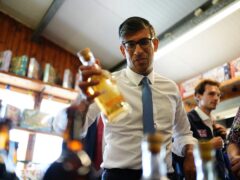 Prime Minister Rishi Sunak holding a glass bottle during a visit to a farm shop in Wales (Aaron Chown/PA)