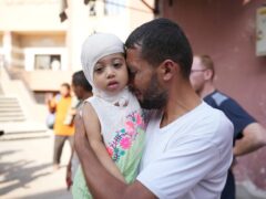 A Palestinian man says goodbye to his sick daughter before she leaves the Gaza Strip to get treatment abroad (Abdel Kareem Hana/AP)