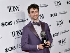 Daniel Radcliffe poses in the press room with the award for best performance by an actor in a featured role in a musical for Merrily We Roll Along (Evan Agostini/Invision/AP)