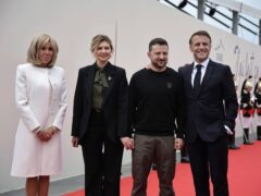Ukrainian President Volodymyr Zelensky and his wife Olena Zelenska, second left, are welcomed by French President Emanuel Macron, right, and his wife Brigitte Macron, at the international ceremony at Omaha Beach, near Saint-Laurent-sur-Mer (Christophe Petit Tesson, Pool via AP)