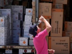 A worker takes a drink from a water bottle as he unloads a trailer in sweltering Weldon Spring, Missouri (AP Photo/Jeff Roberson)
