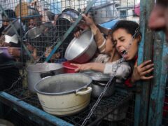 Palestinians line up to receive meals at the Jabaliya refugee camp (Mahmoud Essa/AP)