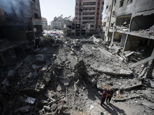 Palestinians look at the aftermath of the Israeli bombing in Nuseirat refugee camp, Gaza Strip (Jehad Alshrafi/AP)