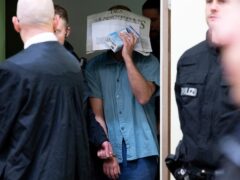A man charged with membership of a terrorist organisation and the preparation of a so-called high treasonous enterprise is led into the courtroom at the Higher Regional Court in Munich (Sven Hoppe/dpa via AP)