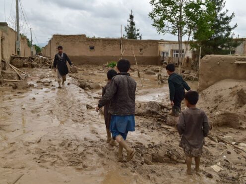 People walk near their damaged homes after heavy flooding in Baghlan province in northern Afghanistan (AP)