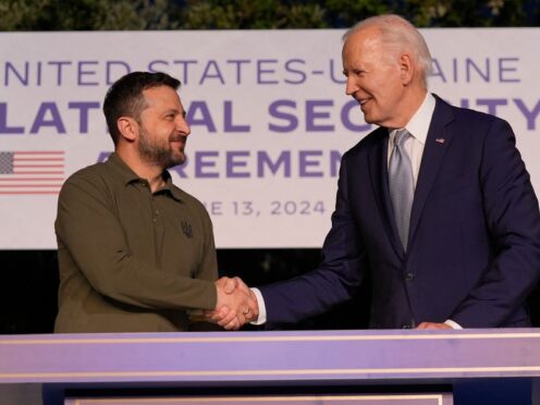 President Joe Biden and Ukrainian President Volodymyr Zelensky, left, shake hands after signing a security agreement on the sidelines of the G7 in Savelletri, Italy (Alex Brandon/AP)