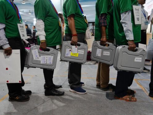 Election officials carry sealed electronic voting machines at a counting centre in Mumbai, India (Rafiq Maqbool/AP)