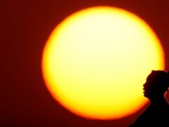 A woman is silhouetted against the setting sun in Kansas City, Missouri (AP)