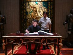 Mr Zelensky signs the guest book beside Philippine President Ferdinand Marcos Jr at the Malacanang presidential palace (Pool Photo via AP)