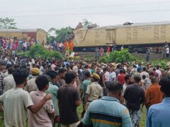Onlookers watch as rescuers work after a cargo train rammed into the Kanchanjunga Express, a passenger train, near New Jalpaiguri station West Bengal state, India (Diptendu Dutta/AP)