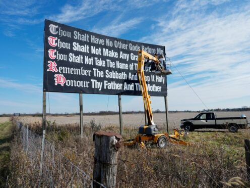 Workers repaint a Ten Commandments billboard off Interstate 71in 2023 (Carolyn Kaster/AP)