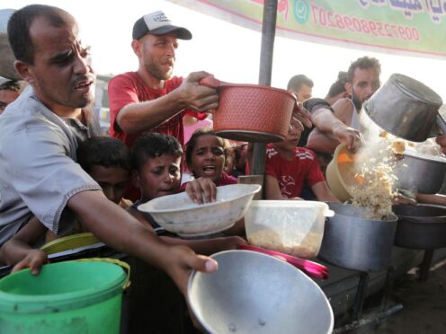 Palestinians collect food aid ahead of the upcoming Eid al-Adha holiday in Khan Younis, Gaza Strip (Jehad Alshrafi/AP)