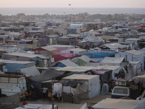 Palestinians displaced by the Israeli air and ground offensive on the Gaza Strip walk through a makeshift tent camp in Khan Younis, Gaza (Jehad Alshrafi/AP)