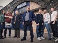 L to R: Honey Mitchell (Emma Barton), Billy Mitchell (Perry Fenwick), Stevie Mitchell (Alan Ford), Phil Mitchell (Steve McFadden), Barney Mitchell (Lewis Bridgeman), Teddy Mitchell (Roland Manookian) and Harry Mitchell (Elijah Holloway). (Jack Barnes/Kieron McCarron/BBC)