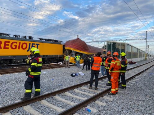 Firefighters stand by two trains that collided in Pardubice (AP Photo/Stanislav Hodina)