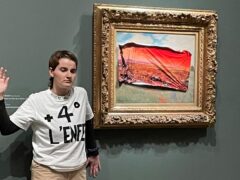 A protester standing next to Poppy Field by Claude Monet at the Orsay museum (Riposte Alimentaire via AP)