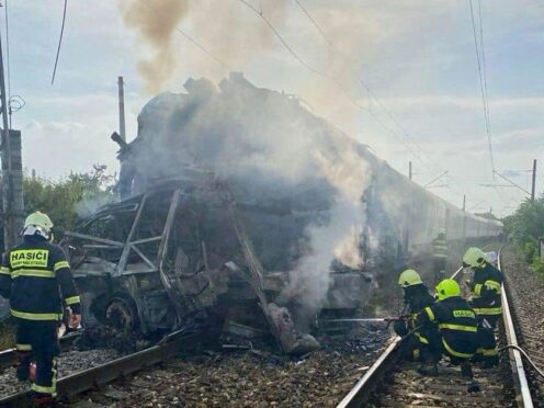 The train engine caught fire after the crash, while the bus was badly damaged and broke into two parts (Slovak Police via AP)