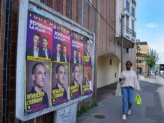 A woman walks past campaign posters for the European election in Colombes, west of Paris, France (Michel Euler/AP)